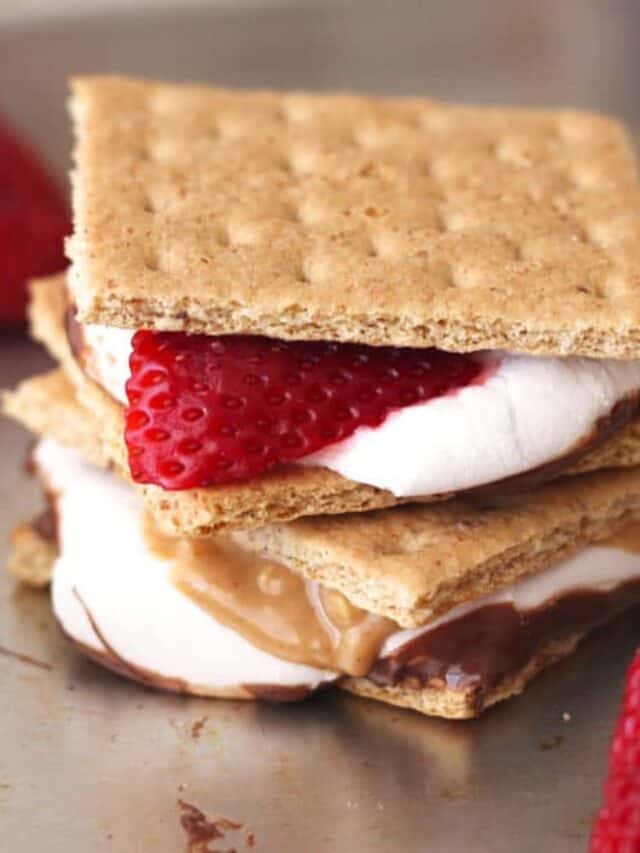 S'mores with fresh strawberry slices and peanut butter on a pan.