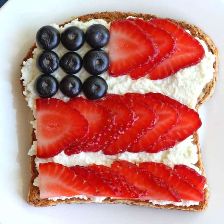 Ricotta cheese topped toast with blueberries and strawberry slices arranged like the American Flag.