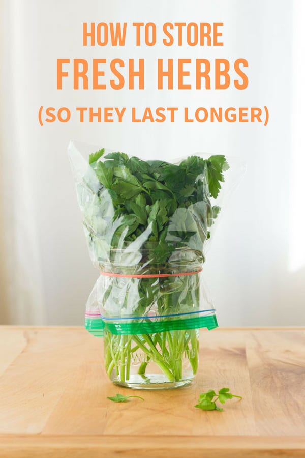 Fresh herbs in a jar covered with a plastic bag.