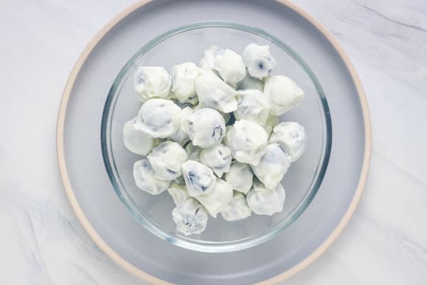 Bowl of frozen blueberries coated in yogurt.