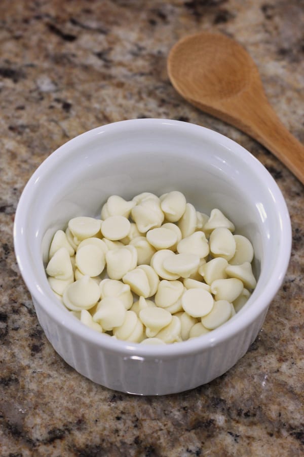 White chocolate chips in a small ramekin on a counter.