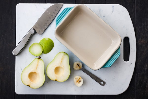 Pear sliced in half with seeds scooped out with a teaspoon.