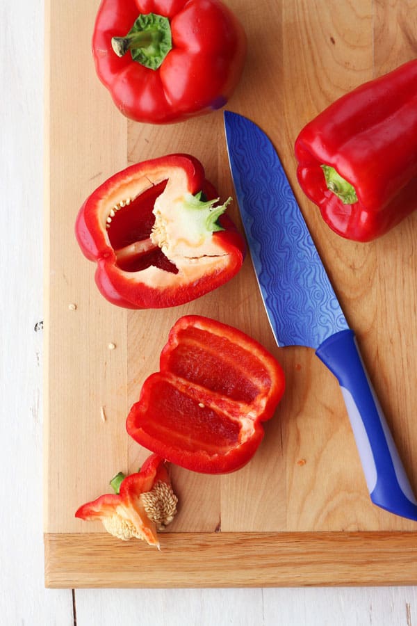 A red pepper sliced open and seeded on a cutting board.