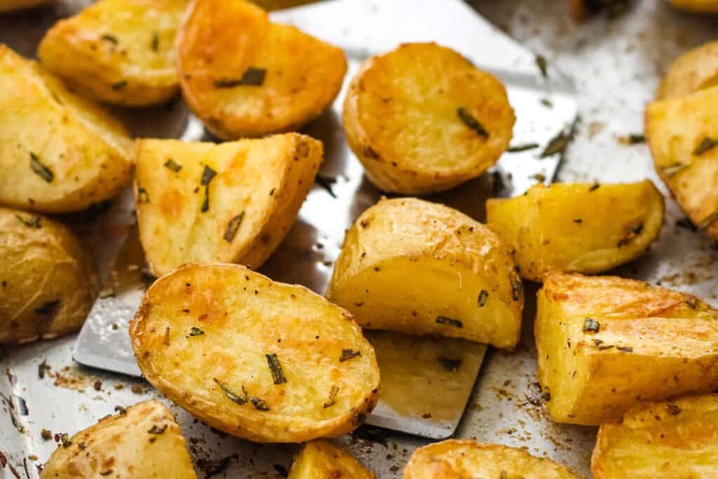 Closeup of golden roasted baby potatoes on a sheet pan.