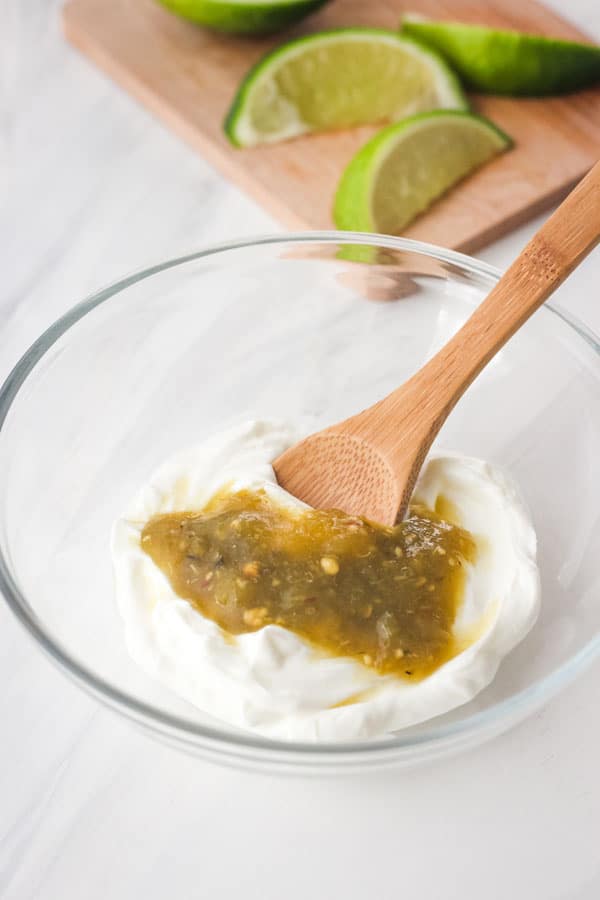 Greek yogurt and green salsa in a small glass bowl.