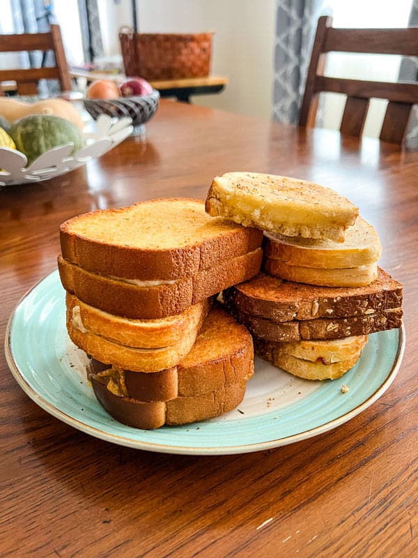 Dining table with plate of stacked grilled cheese sandwiches.