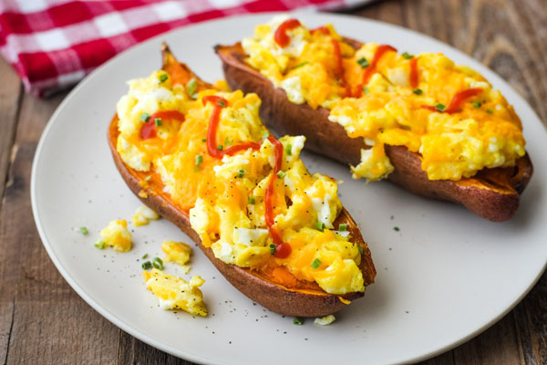 A tan plate with scrambled egg topped sweet potatoes.