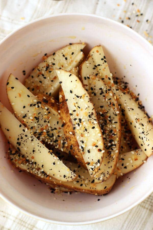 Bowl of potato wedges with everything bagel seasoning.