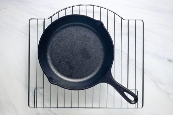 An 8 inch cast iron skillet on a toaster oven cooking rack.