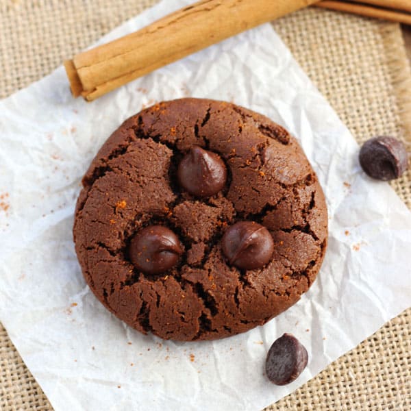 Spicy hot chocolate cookie next to a cinnamon stick.