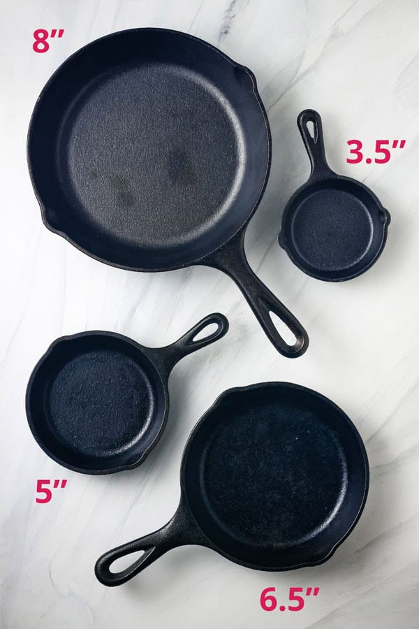 Pans are arranged on a table with size markings.