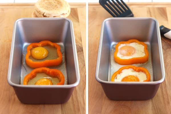 A loaf pan with eggs baked in orange bell pepper slices.