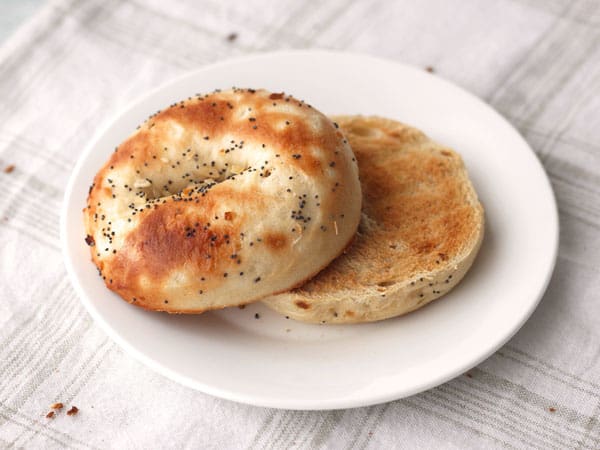 Toasted bagel slices on a white plate.