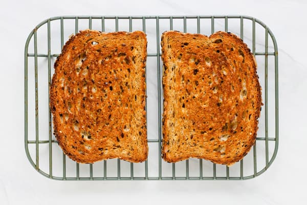 Toasted bread slices cooling on a rack.