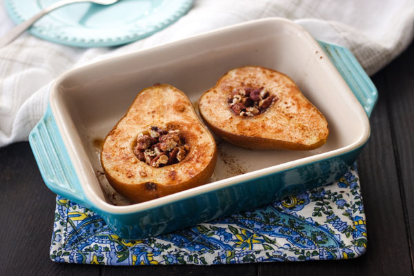 A blue 7 x 5 baking dish filled with pear halves.