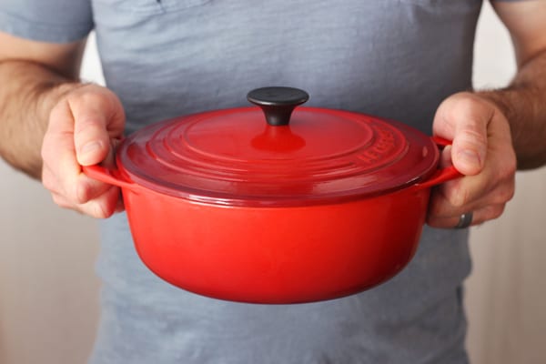 Man holding a Red 2.75 quart Le Creuset Shallow Dutch Oven