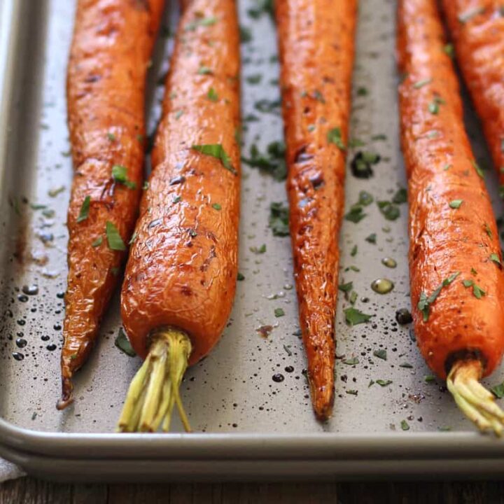 Closeup of whole roasted carrots on a pan.