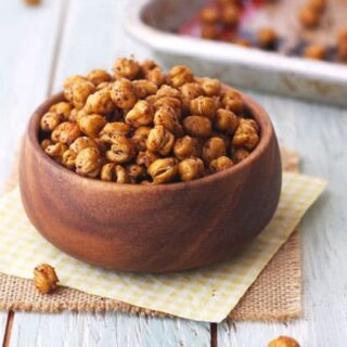 A small wooden bowl filled with roasted chickpeas.