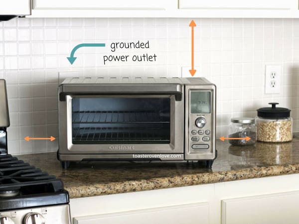 Toaster oven on a kitchen counter with arrows pointing to cabinets and power outlet.