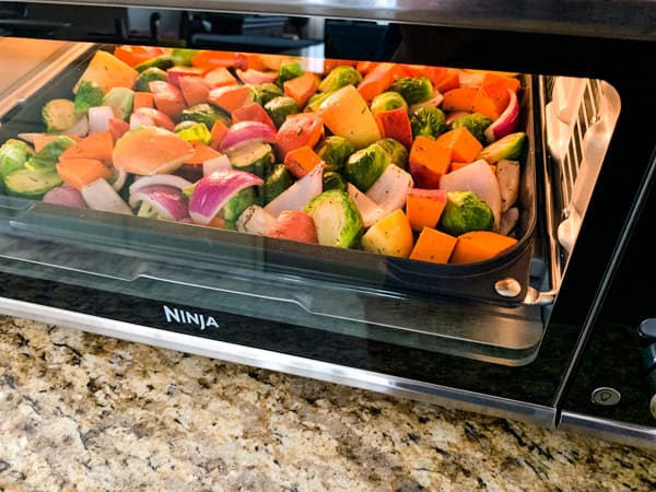 Sheet pan meal cooking inside a ninja foodi oven.