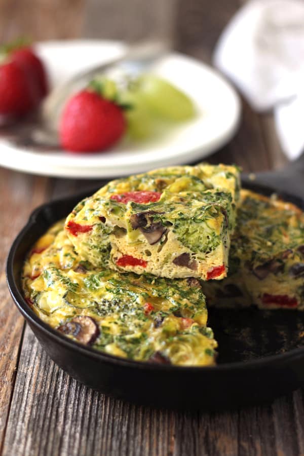  A frittata cooked in a mini cast iron skillet on a wooden table.