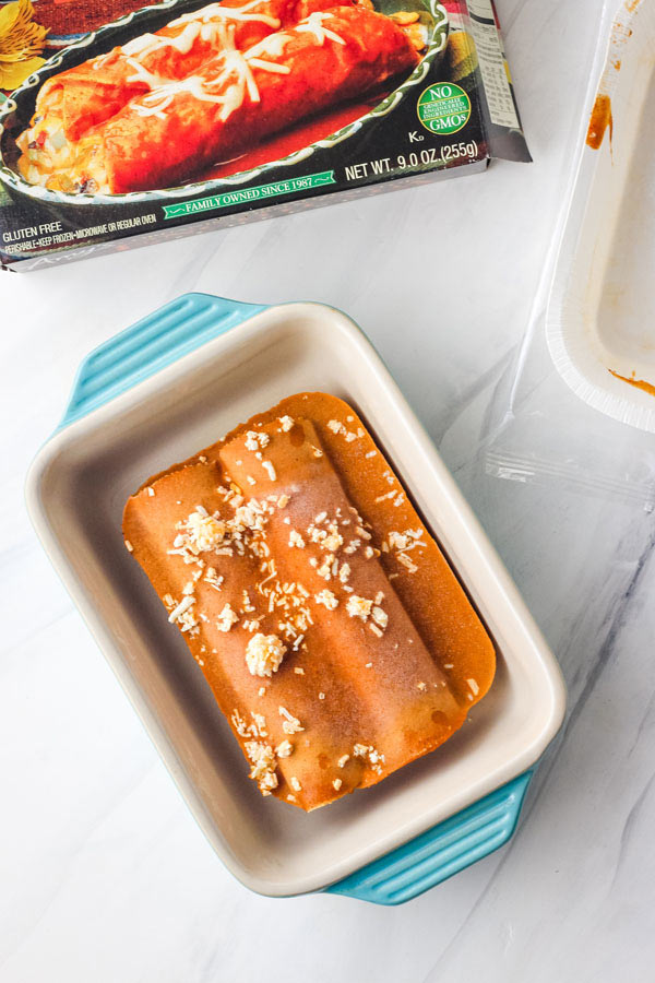 Frozen enchiladas in a small blue baking dish.