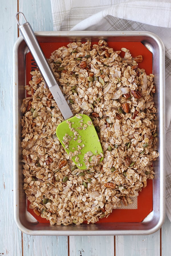 Uncooked granola pressed into a quarter sheet pan.