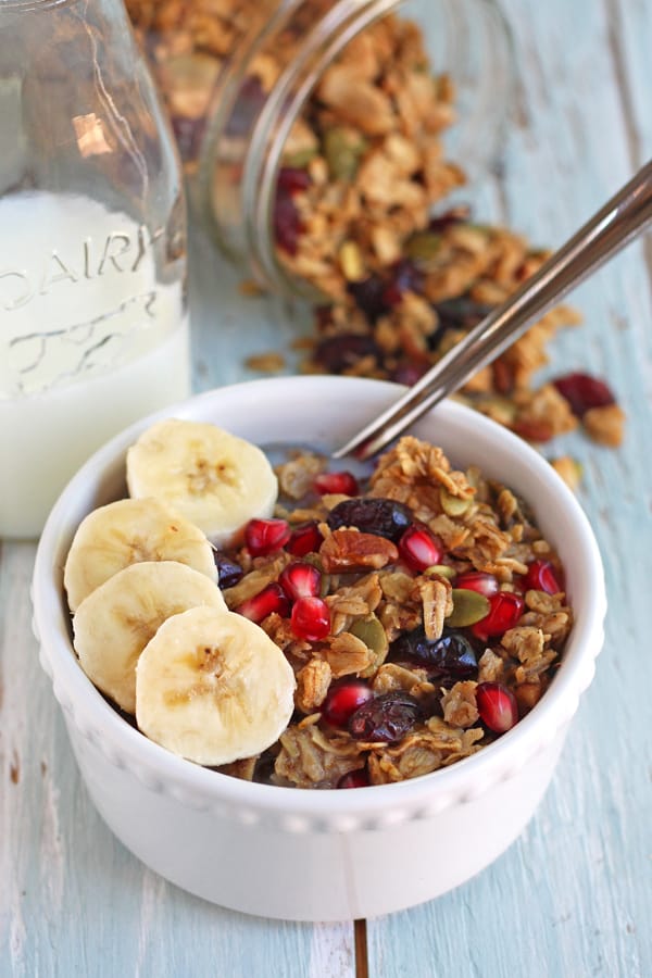 Small bowl of granola with bananas and a bottle of milk.