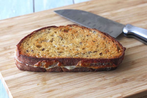 Browned and crispy grilled cheese on a cutting board.