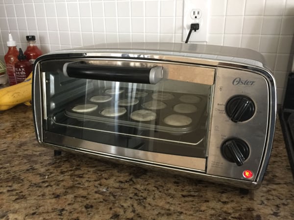 Mini muffins baking in a little toaster oven.