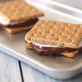 Two gooey s'mores on a baking pan.