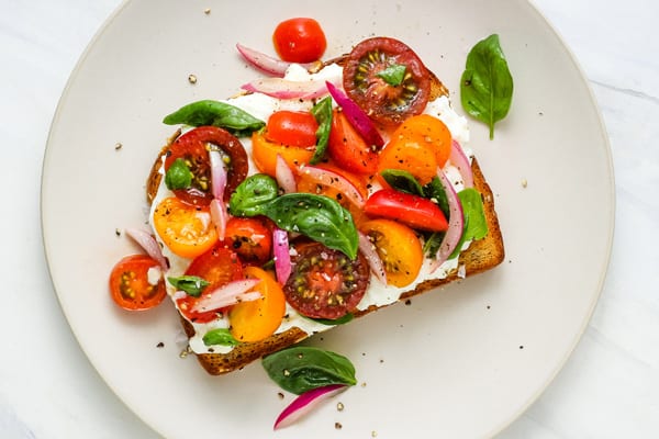 Tomato salad, basil, and cheese on toast.